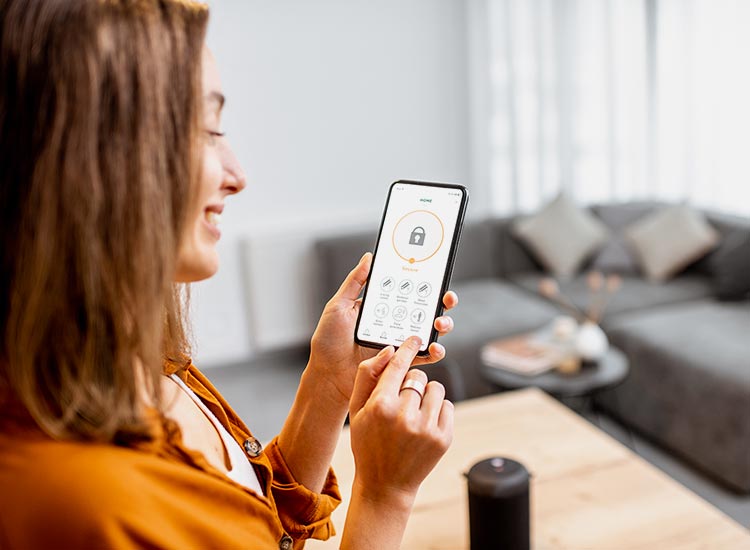 Une femme consultant son système d'alarme sur son téléphone